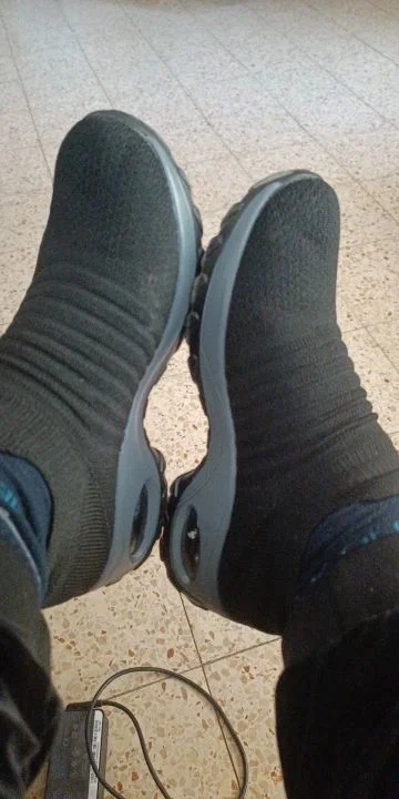 Cliente usando o tênis preto no trabalho